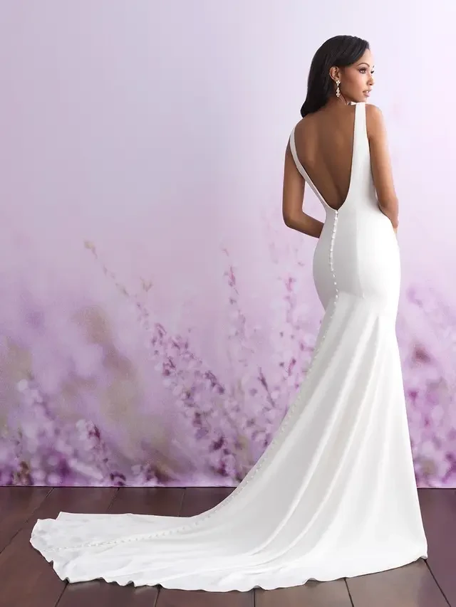 model is wearing a sleeveless open back sheath bridal gown