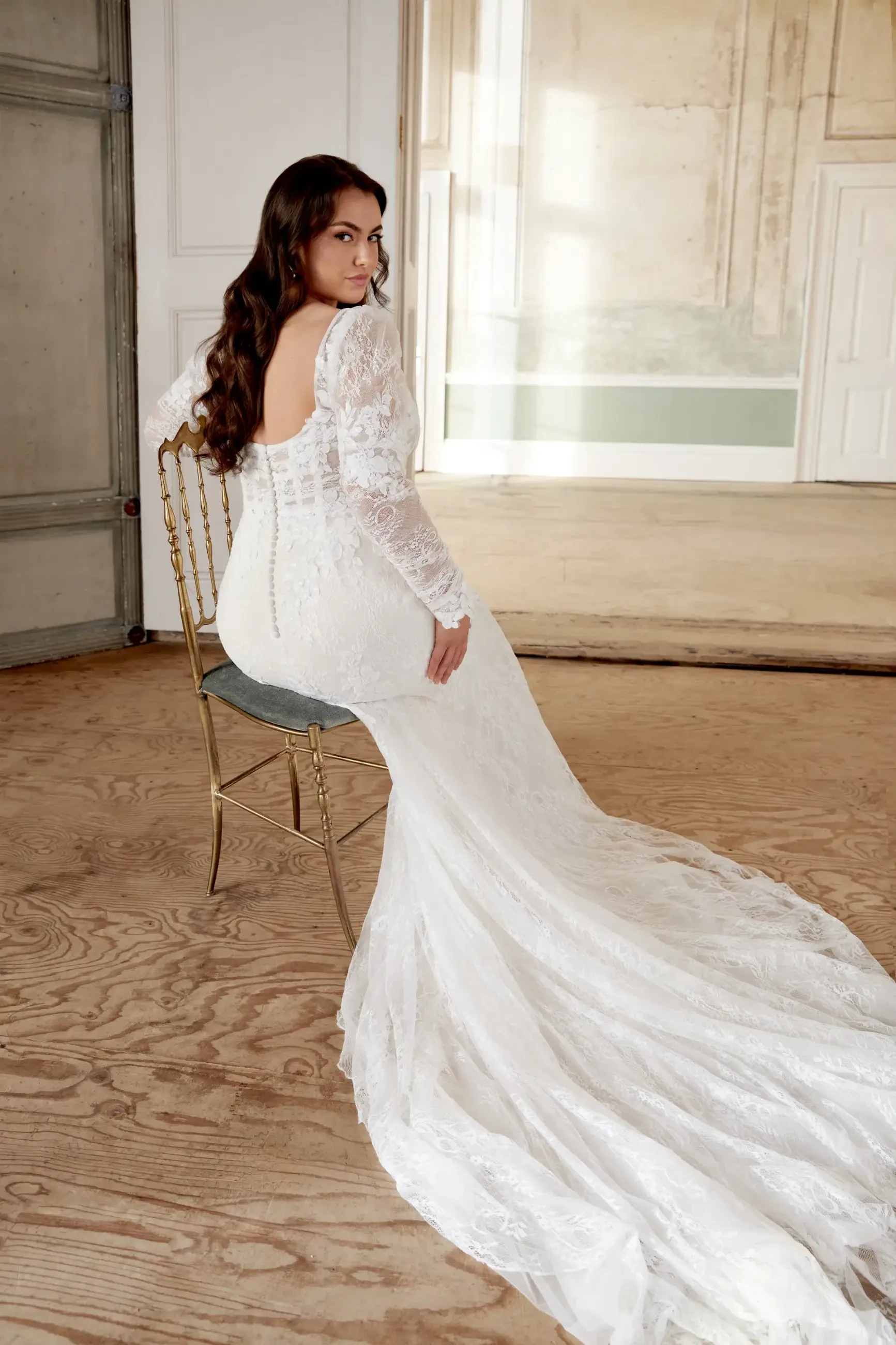model is wearing a long sleeve lace fit and flare wedding dress
