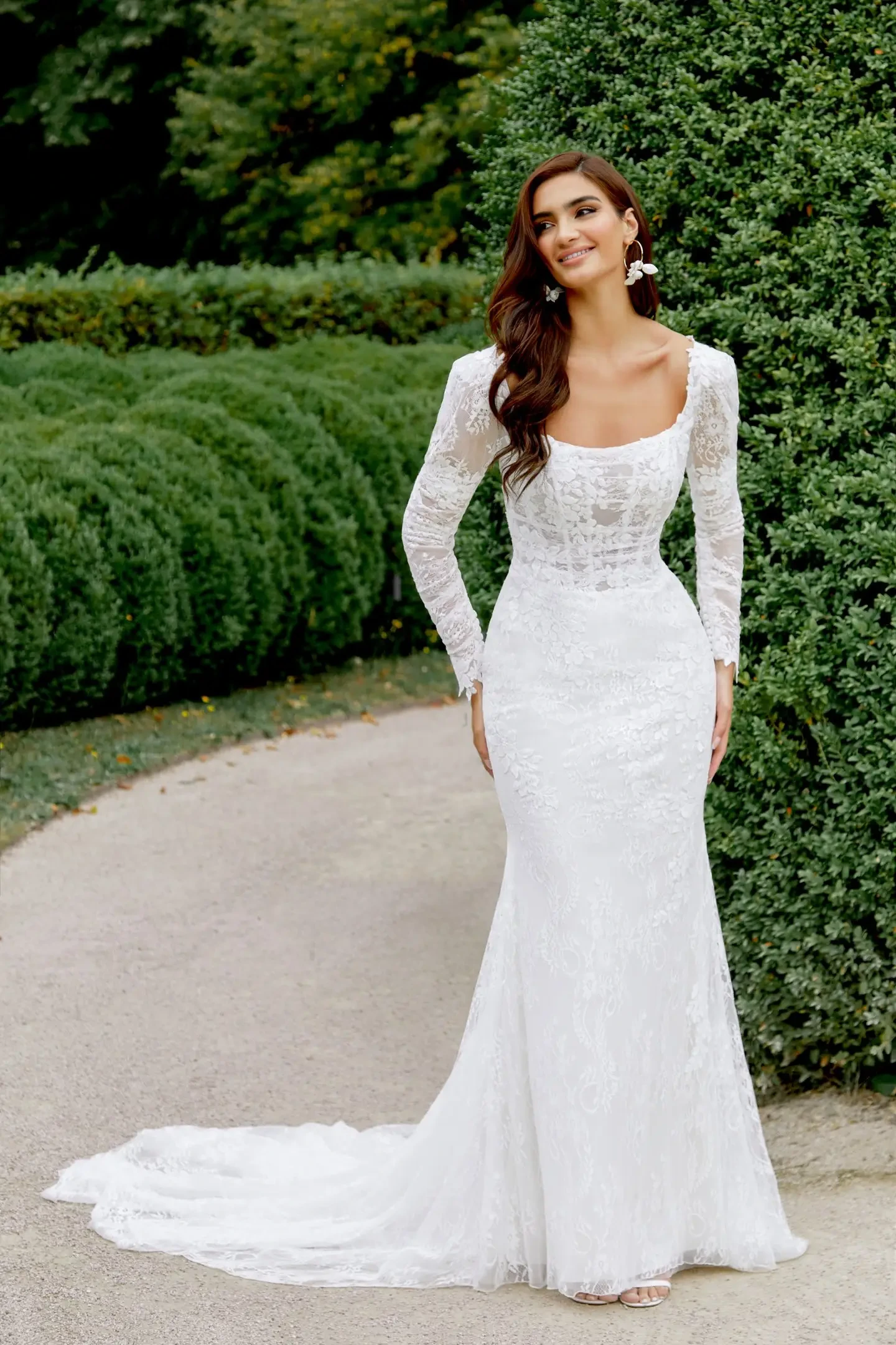 model is wearing a long sleeve lace fit and flare wedding dress