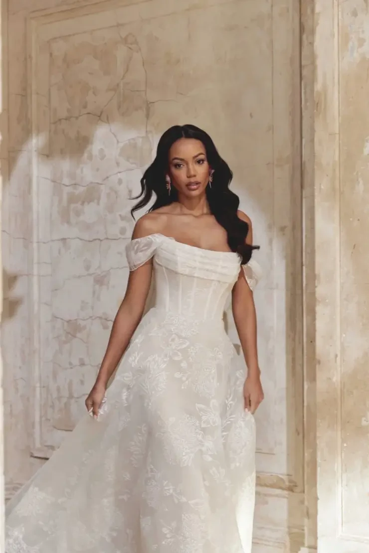model is wearing an off the shoulder a-line bridal gown
