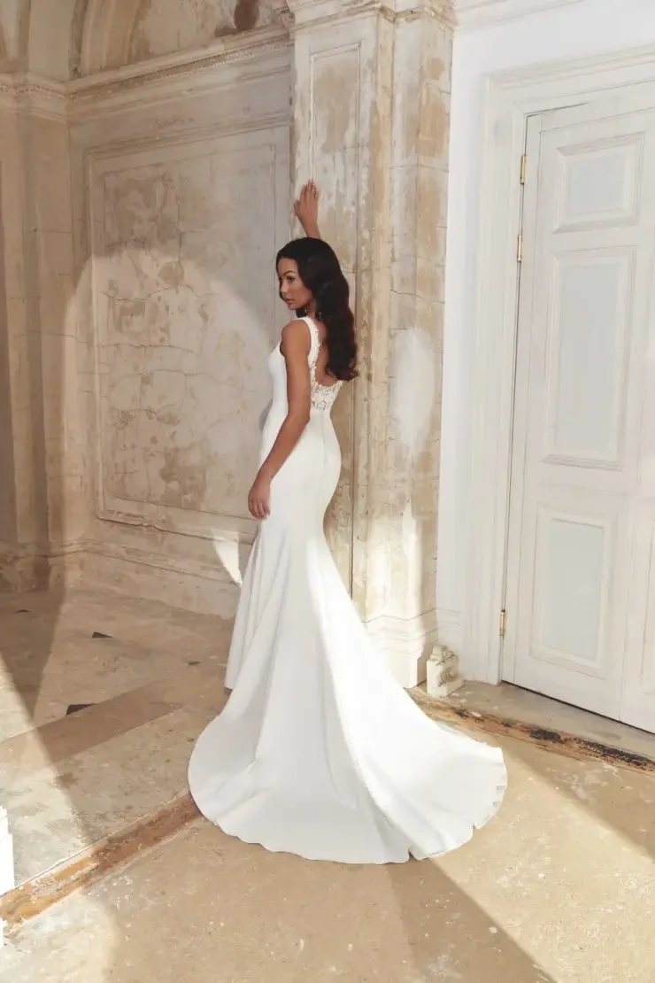 model is wearing a sleeveless minimalist wedding dress