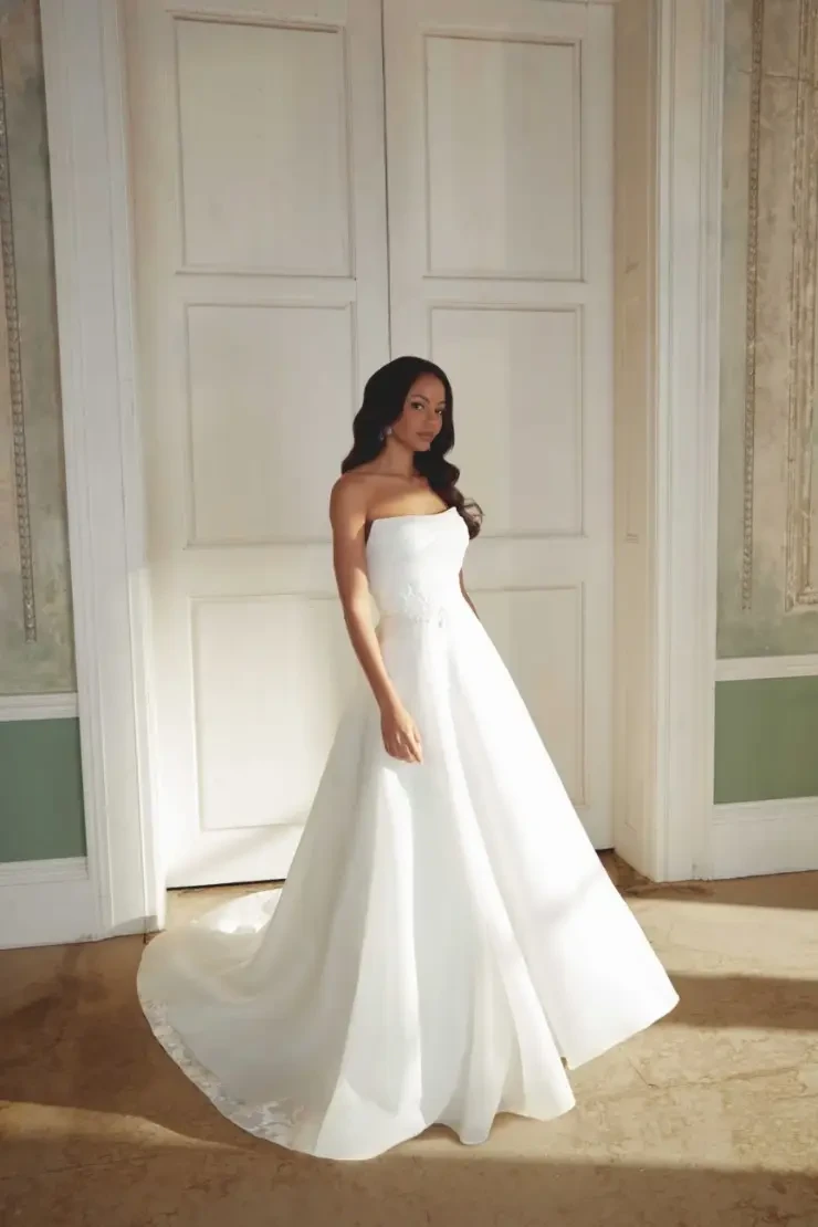 model is wearing a strapless ball gown wedding dress