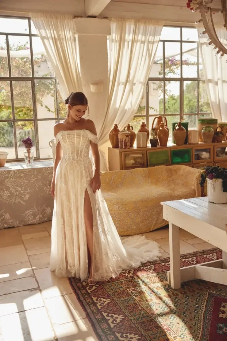 model is wearing an off the shoulder a-line lace wedding dress