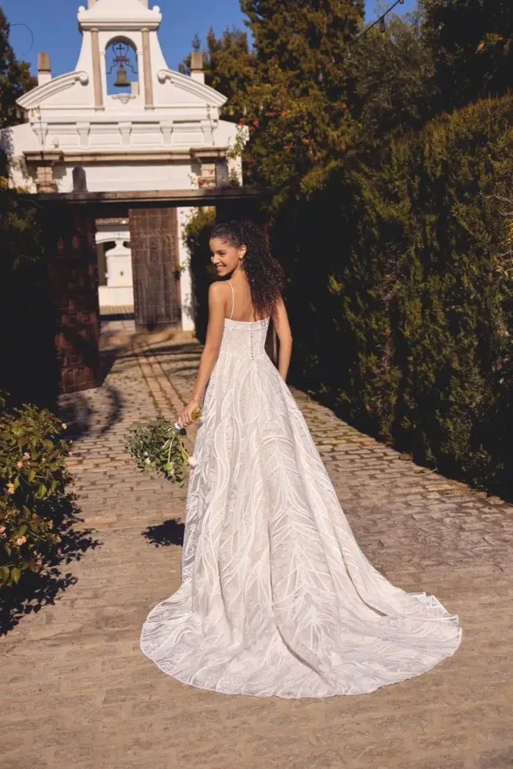 model is wearing a sleeveless a-line wedding dress with spaghetti straps