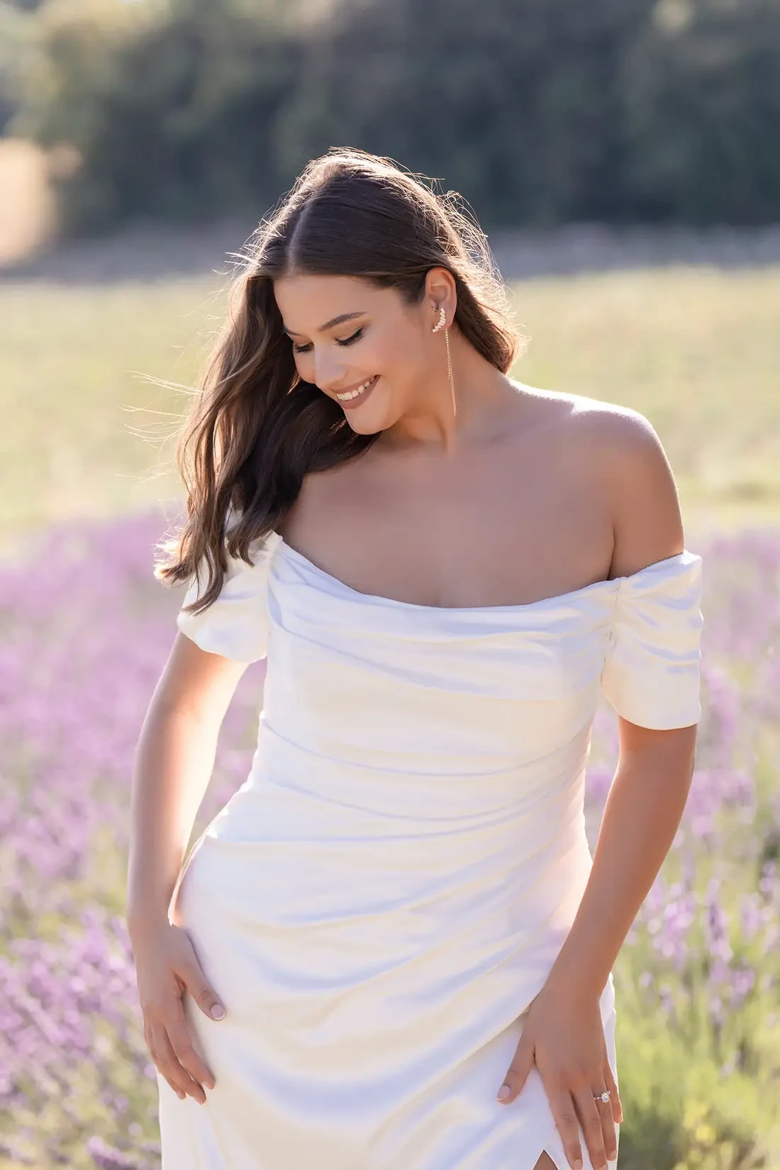 model is wearing a plus size off the shoulder bridal gown