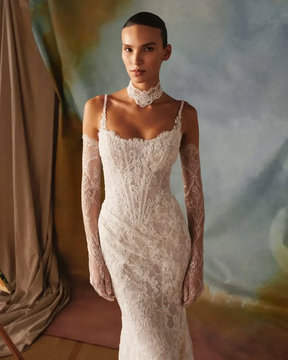 model is wearing a sleeveless lace wedding dress