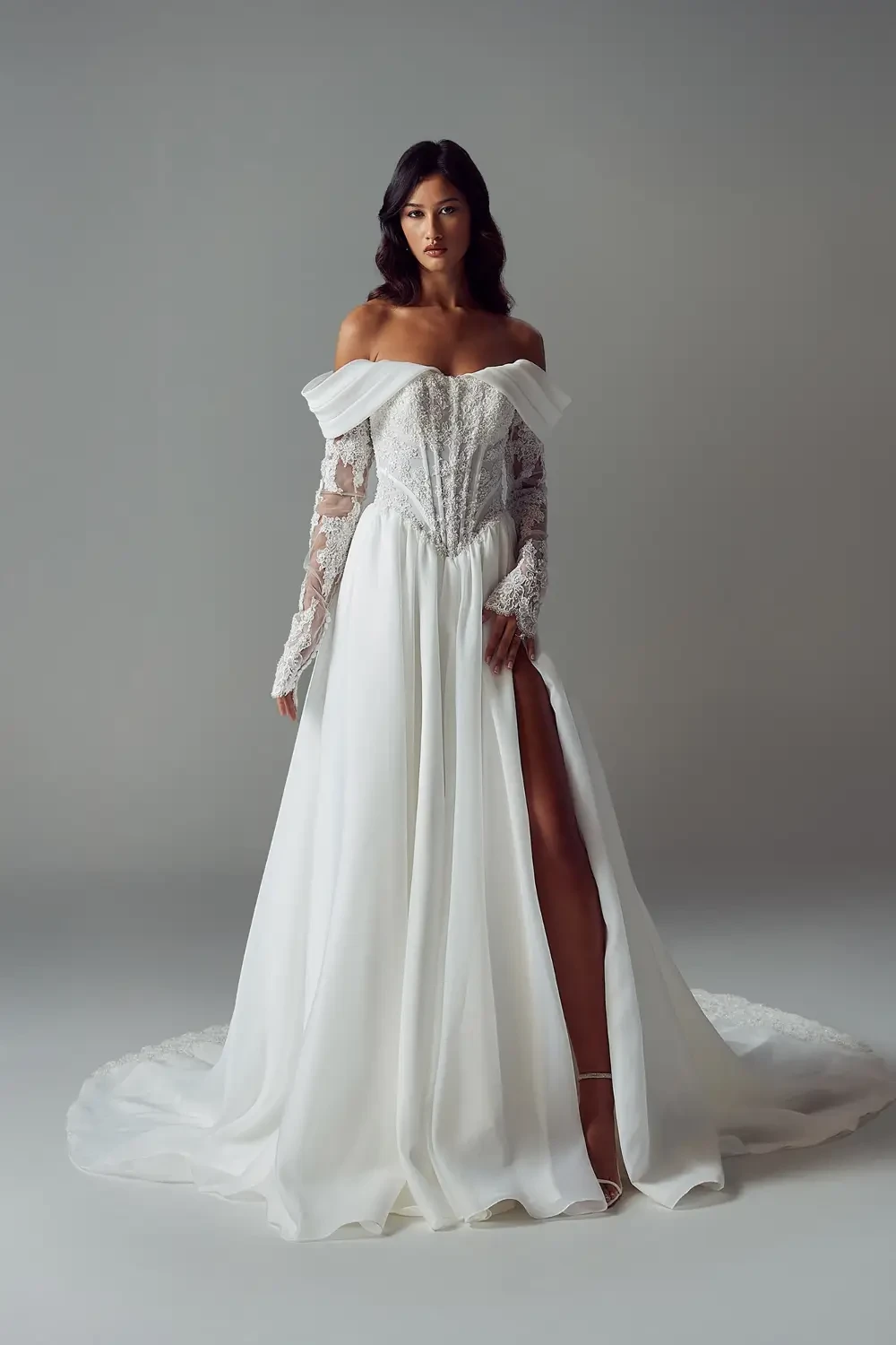 model is wearing an off the shoulder drop waist bridal gown