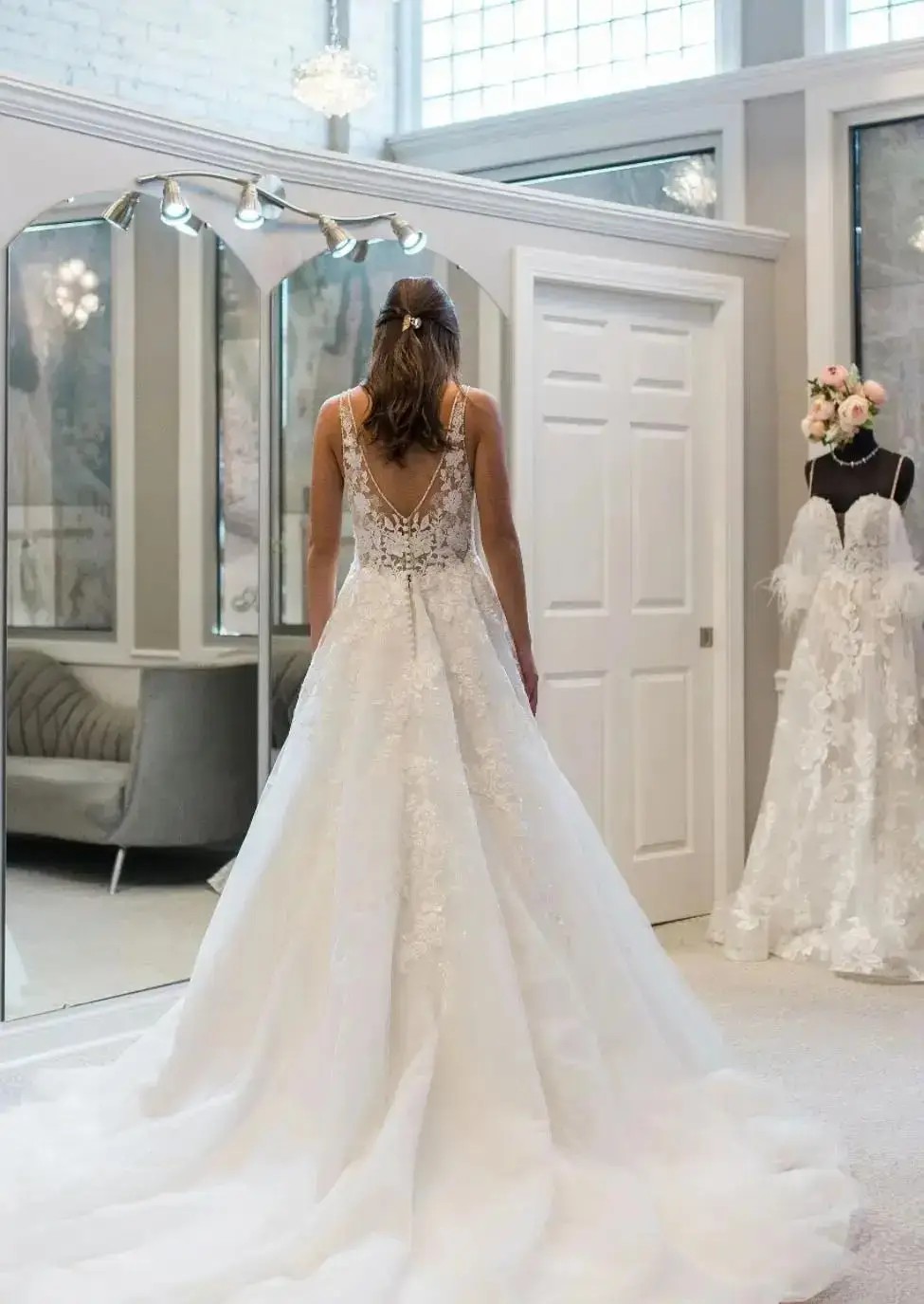 image shows a woman trying on a wedding dress from the back